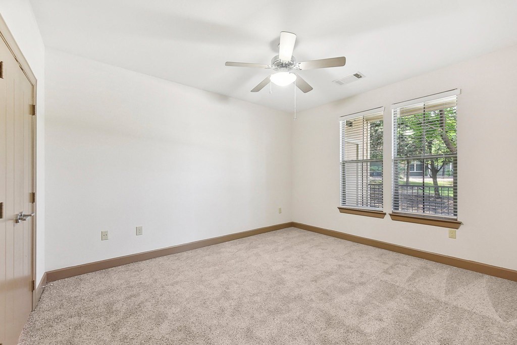 an empty living room with a ceiling fan and a window at Lakeline East Apartments, Texas