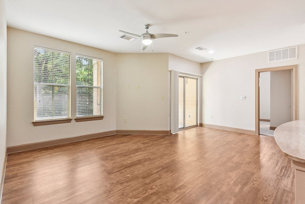 an empty living room with wood floors and a ceiling fan at Lakeline East Apartments, Texas, 78613