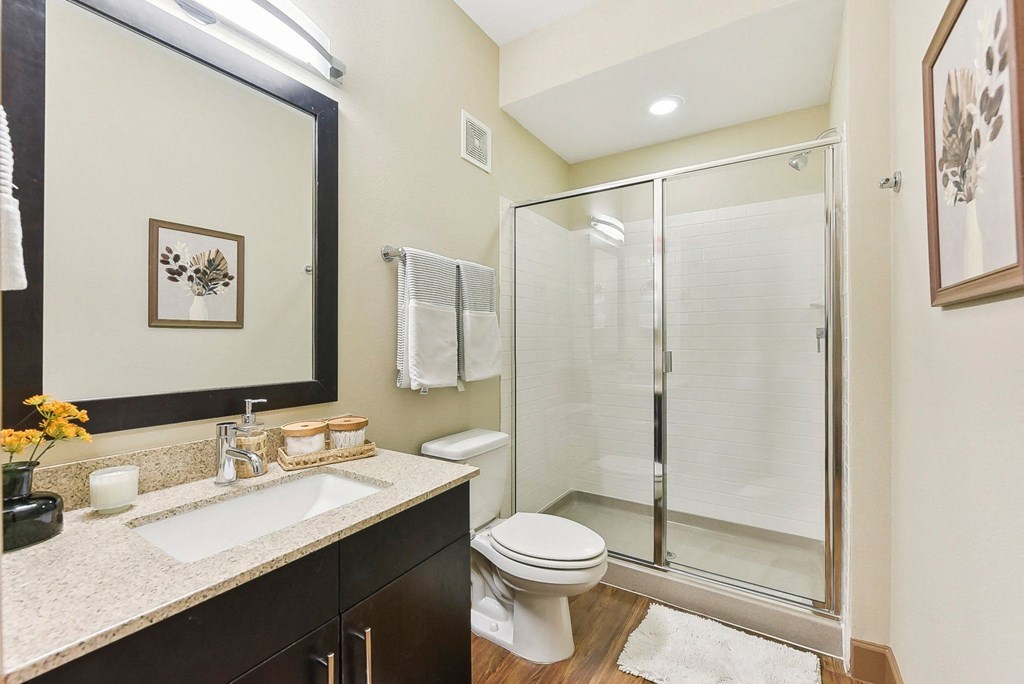 a bathroom with a shower toilet sink and mirror at Lakeline East Apartments, Cedar Park, 78613