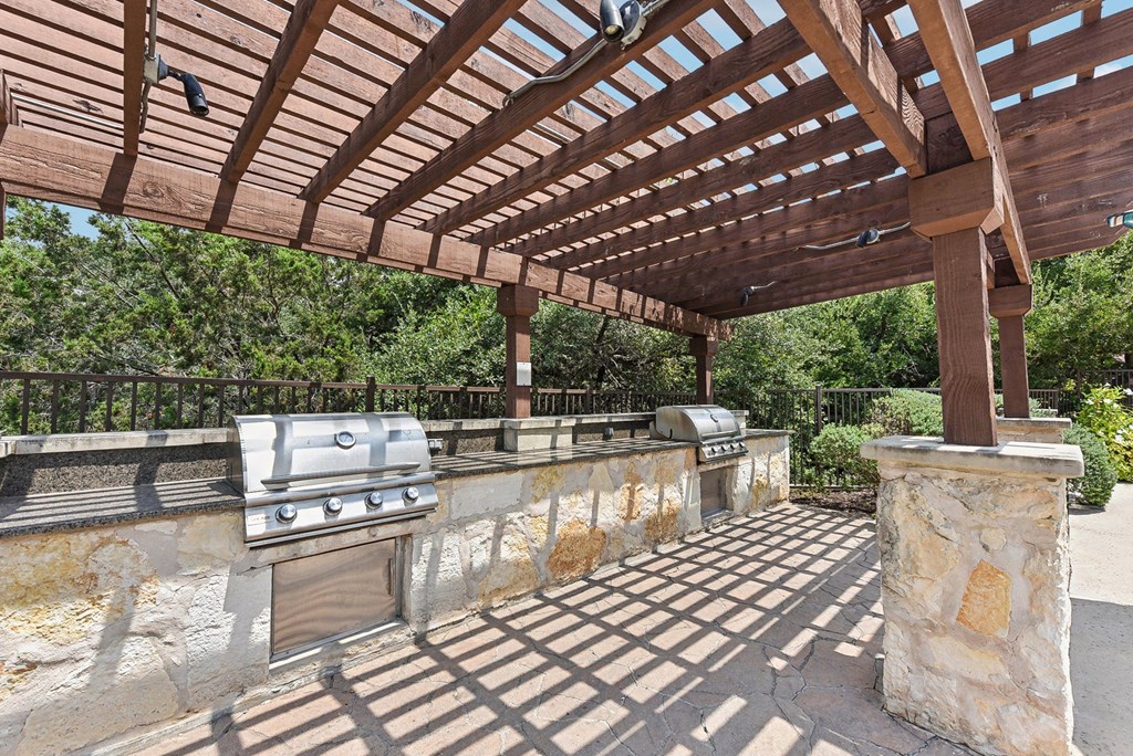 a patio with a barbecue grill and a pergola at Lakeline East Apartments, Cedar Park, 78613