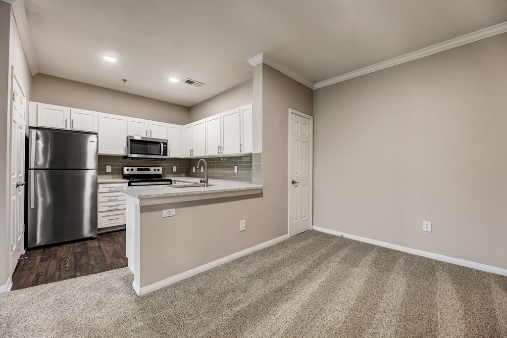 an empty kitchen with stainless steel appliances and white cabinets at Ventana Oaks Apartments, Austin, Texas