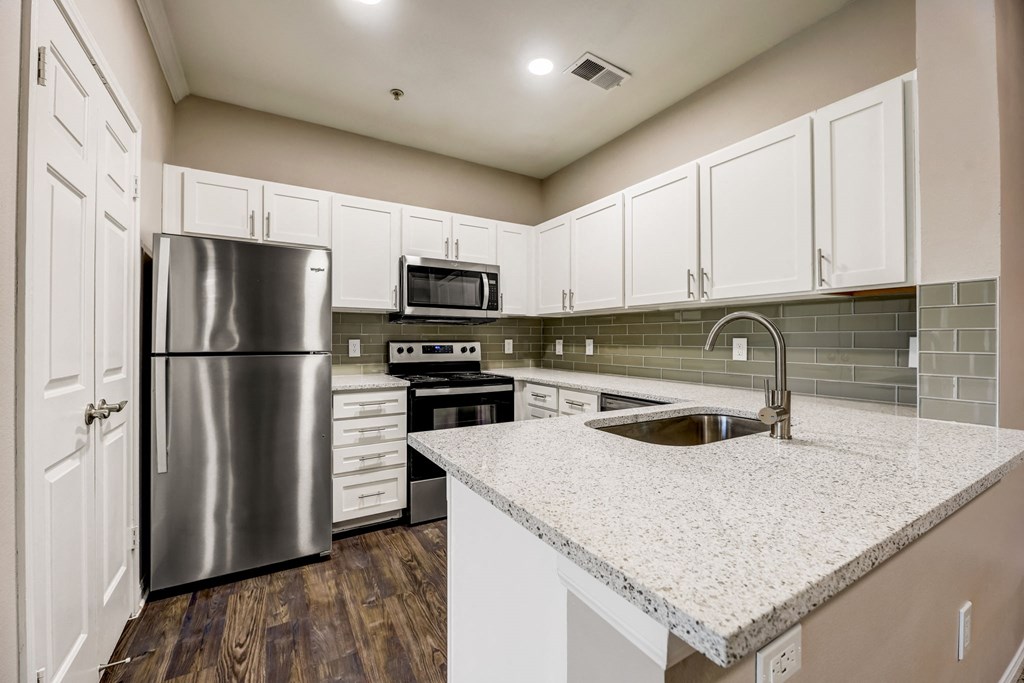 a kitchen with white cabinets and stainless steel appliances at Ventana Oaks Apartments, Austin, 78717