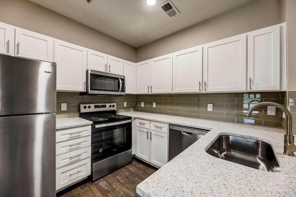 a kitchen with white cabinets and stainless steel appliances at Ventana Oaks Apartments, Austin