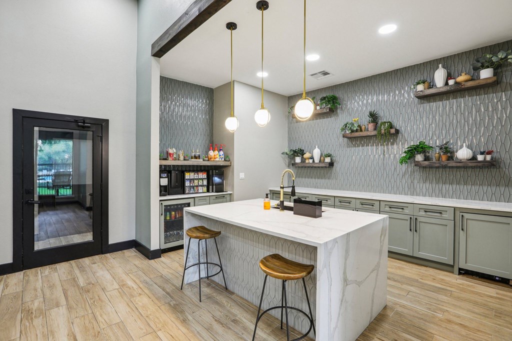 a kitchen with a marble counter top and two stools at Ventana Oaks Apartments, Austin, TX