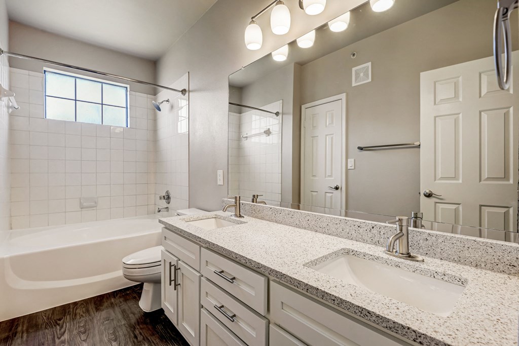 a bathroom with a sink and a toilet and a tub at Ventana Oaks Apartments, Austin