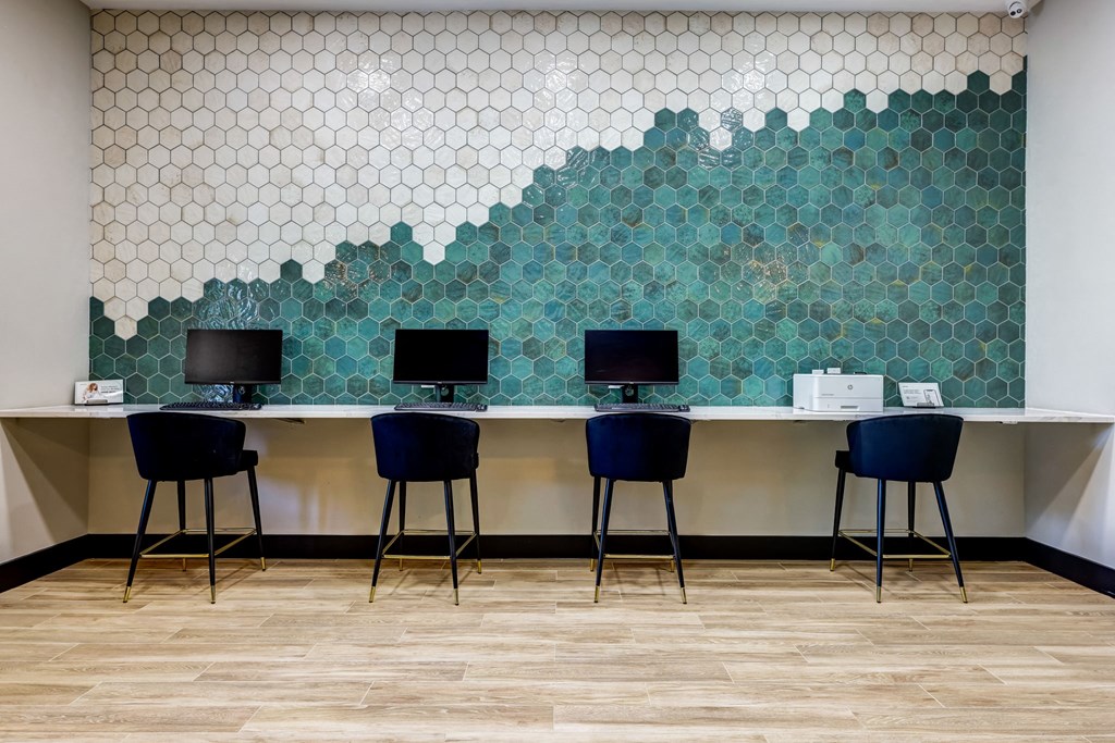 a row of desks with blue stools in front of a wall at Ventana Oaks Apartments, Austin, Texas