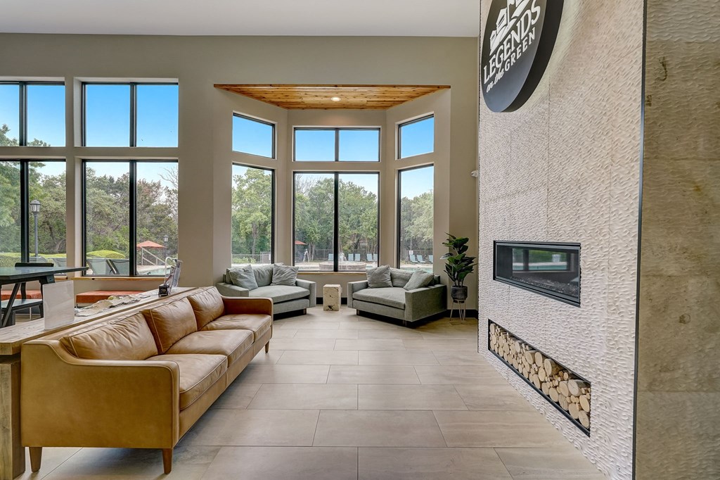 a living room with a fireplace and large windows