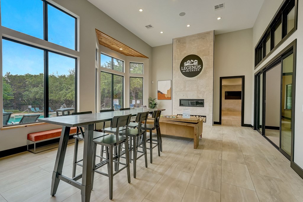 a long bar with stools in a kitchen with large windows at Legends on the Green Apartments, San Antonio, Texas