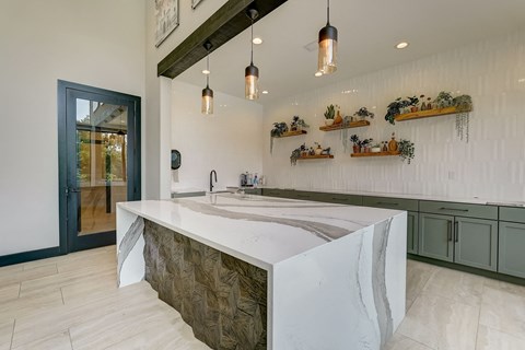 the kitchen has a large island with a marble counter top