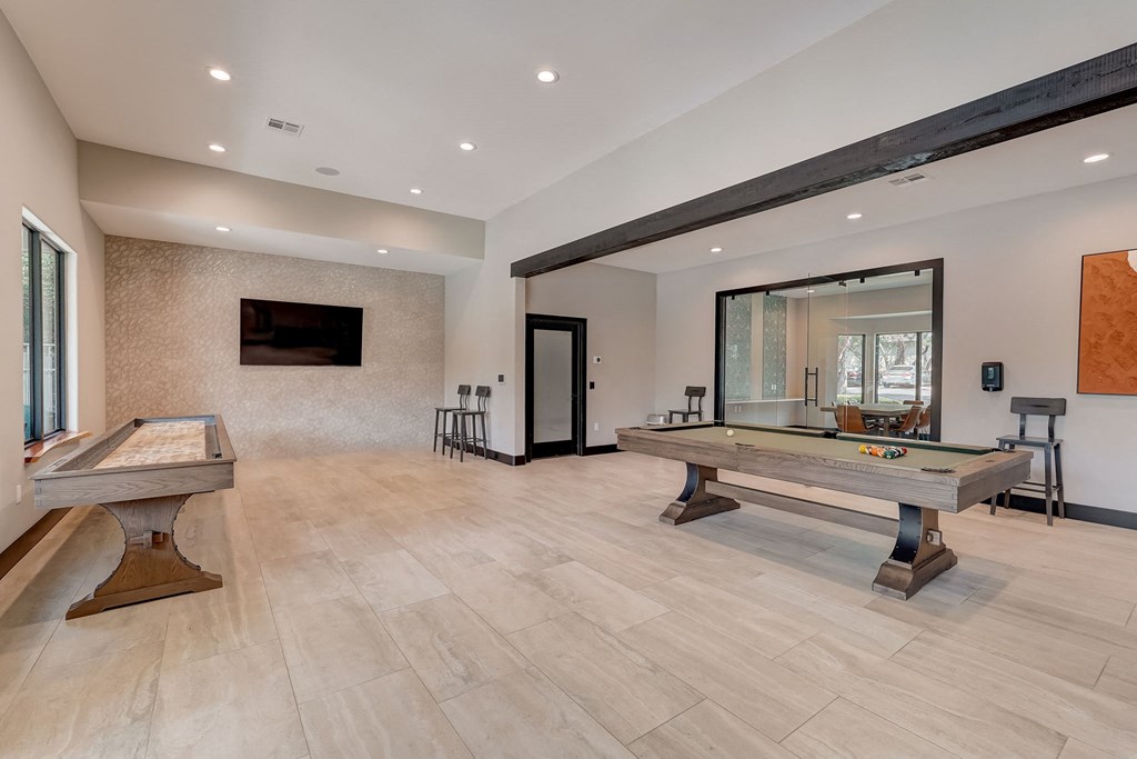 a game room with a pool table and a tv
