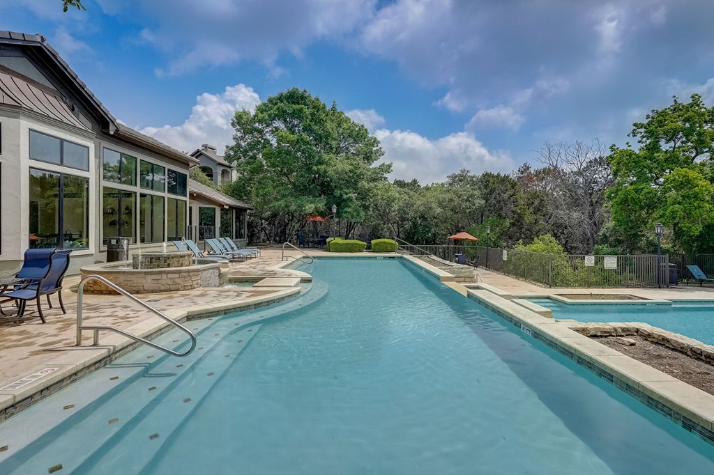 a swimming pool with a house in the background at Legends on the Green Apartments, San Antonio, TX, 78232