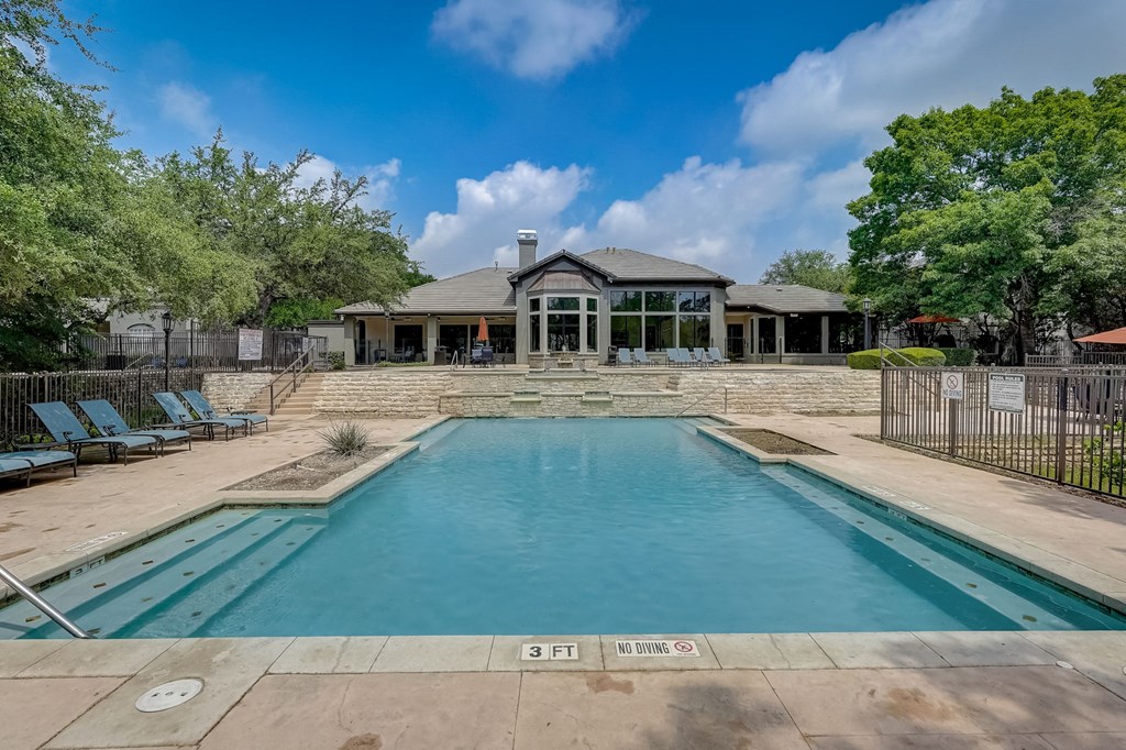 a swimming pool with a house in the background