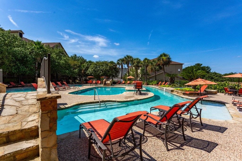 a resort style pool with lounge chairs and umbrellas at The Verandah, Austin, TX, 78726