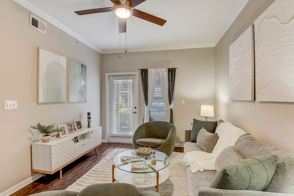 a living room with a ceiling fan and a couch at Artisan Apartments & Shops, Austin, TX