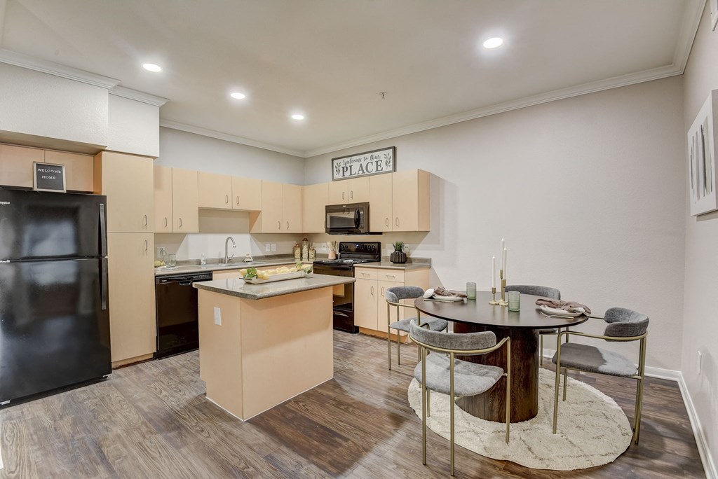 a kitchen with an island and a dining table with chairs at Artisan Apartments & Shops, Austin, 78729