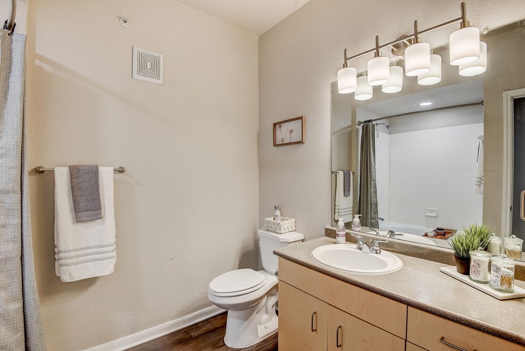 a bathroom with a sink and a toilet and a mirror at Artisan Apartments & Shops, Austin, Texas, 78729