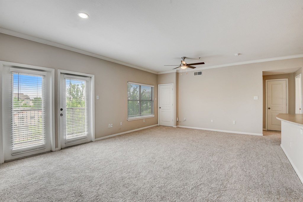 an empty living room with doors and a ceiling fan at Artisan Apartments & Shops, Austin, TX, 78729