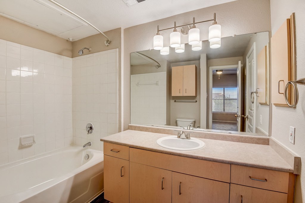 a bathroom with a sink and a tub and a mirror at Artisan Apartments & Shops, Austin, Texas, 78729