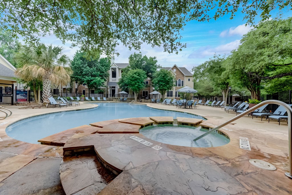 a swimming pool with chairs and trees and a resort style pool