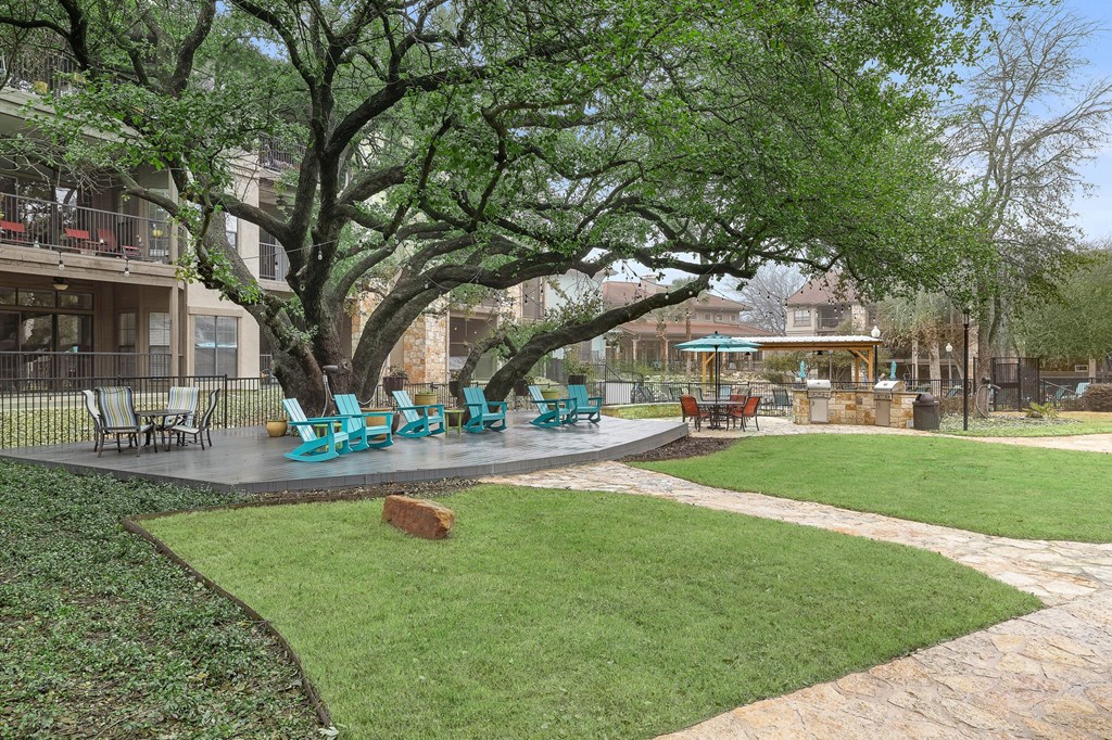 a patio with chairs and a tree in a courtyard at Waters Edge Apartment Homes, Georgetown, 78626
