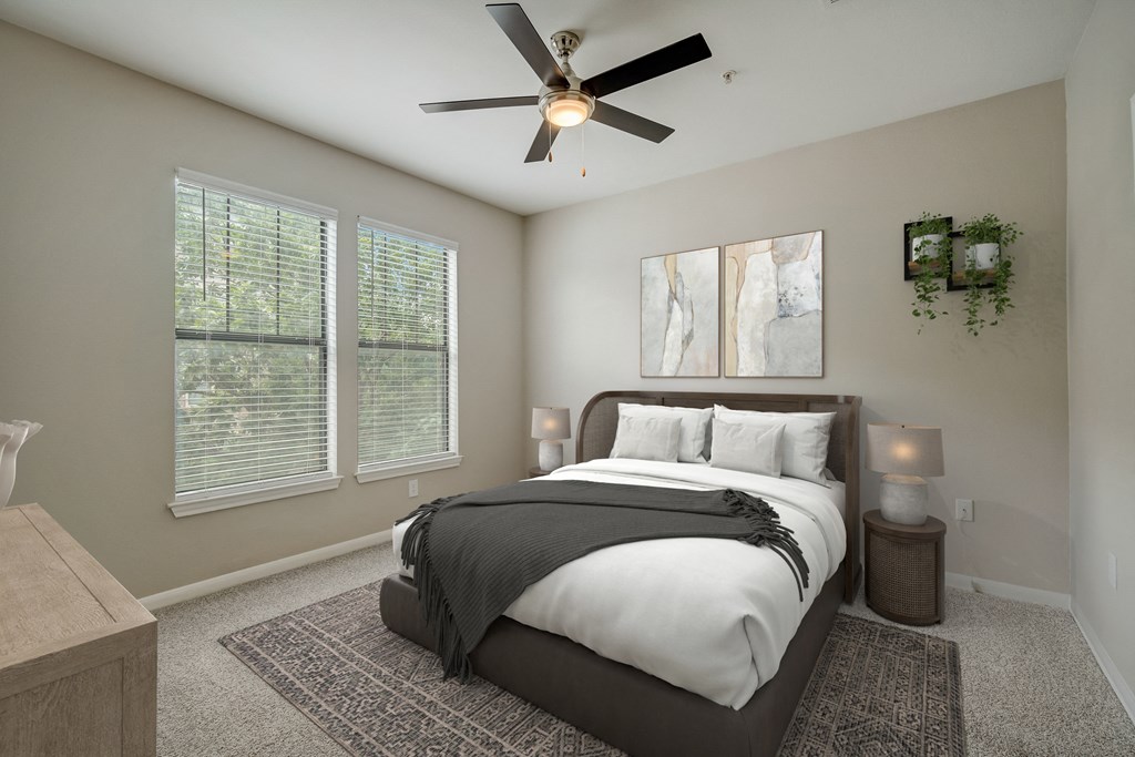 a bedroom with a large bed and a ceiling fan