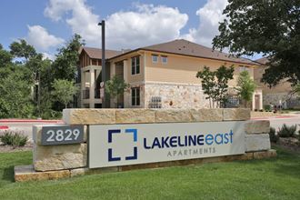 a view of the lakeline east apartments sign with a house in the background