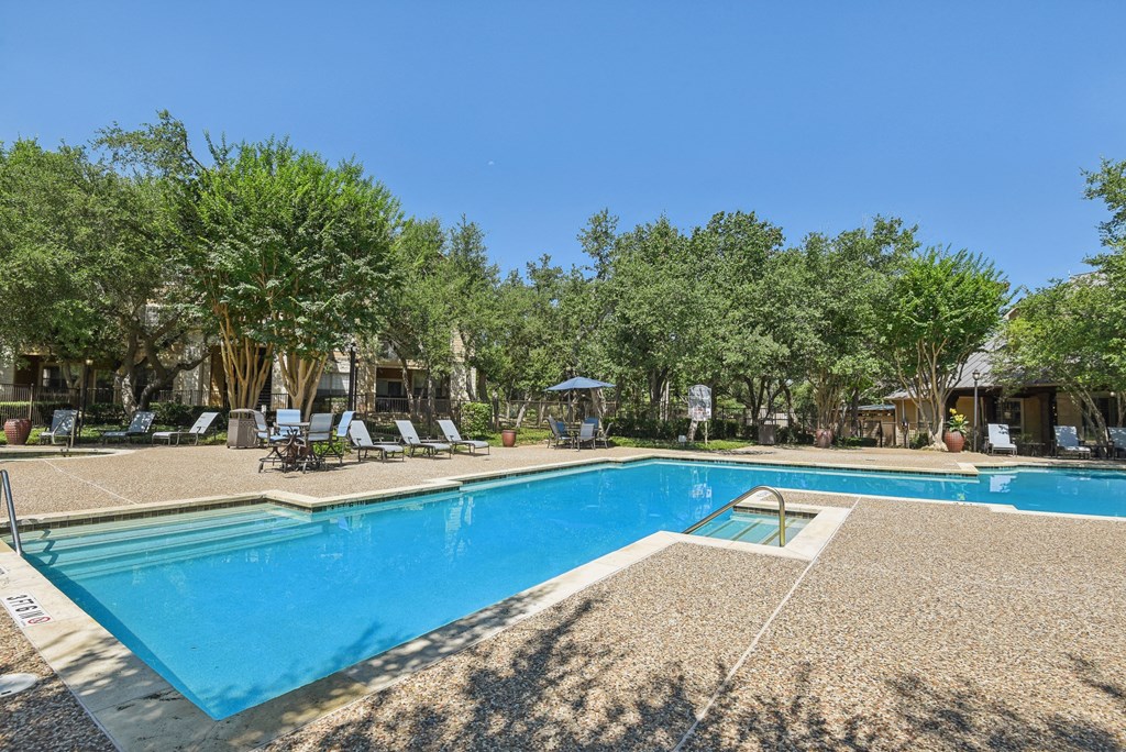 a swimming pool with chairs and trees around it at Sonterra Apartment Homes, Austin, 78726