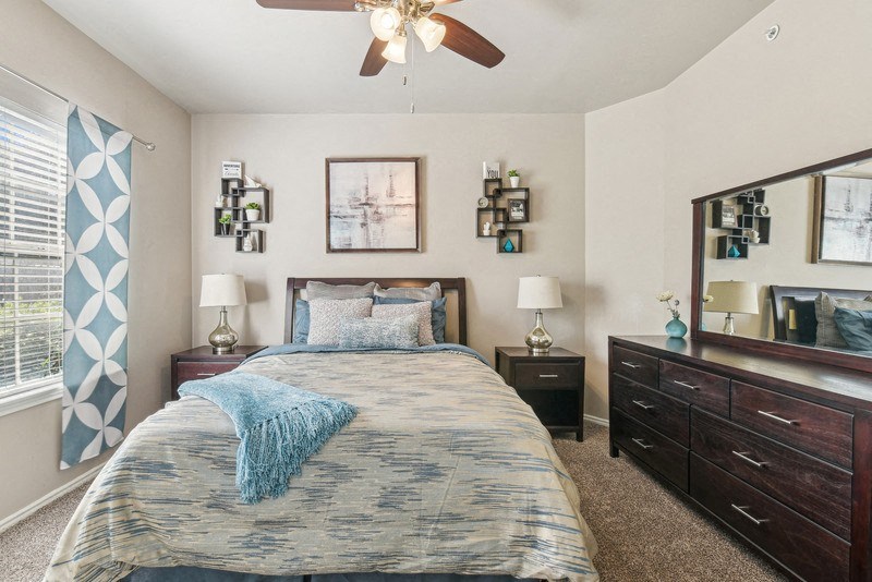a bedroom with a bed and a ceiling fan at TalaVera Apartments, San Antonio