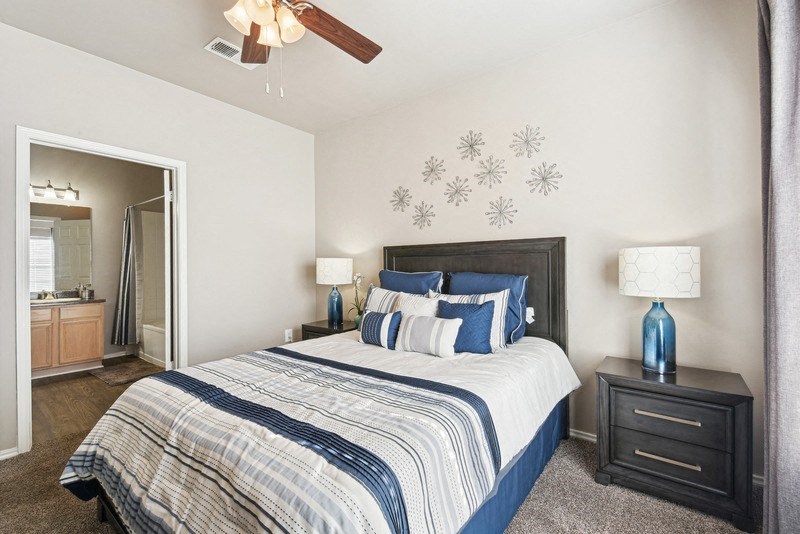 a bedroom with a bed and a ceiling fan at Legends on the Green Apartments, San Antonio
