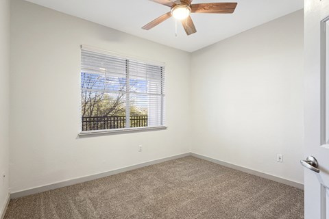 an empty room with a large window and a ceiling fan at The Legends at Eagle Mountain Lake, Fort Worth, TX, 76179