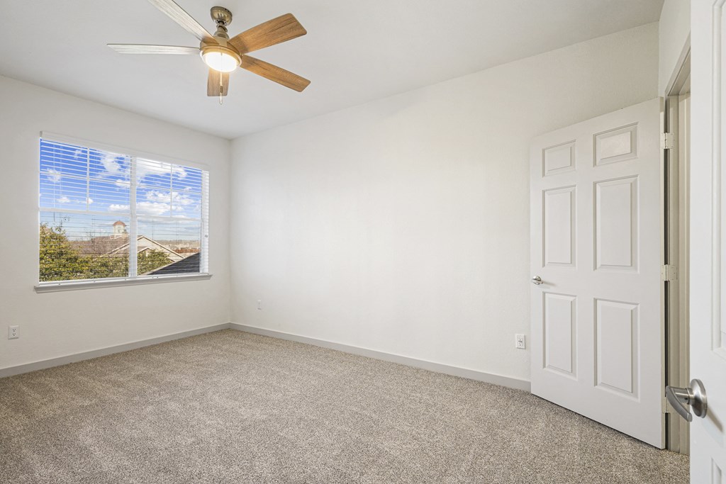 an empty living room with a ceiling fan and a window at The Legends at Eagle Mountain Lake, Fort Worth, Texas