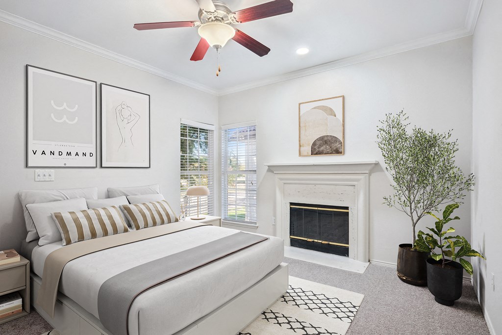 a bedroom with a bed and a fireplace at La Ventura Apartments, Plano, Texas