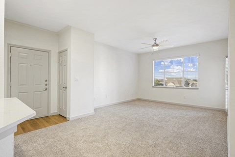 an empty living room with white walls and a ceiling fan at The Legends at Eagle Mountain Lake, Fort Worth