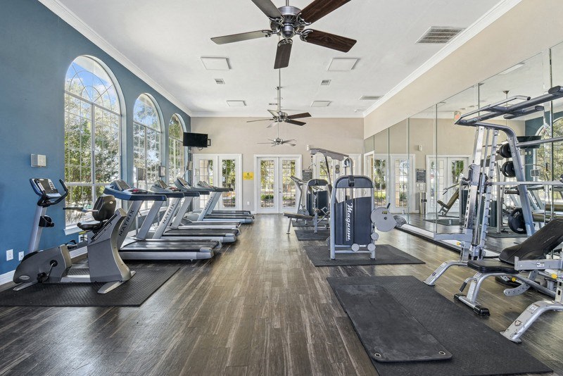 the mansion has a gym with cardio machines and windows at TalaVera Apartments, San Antonio