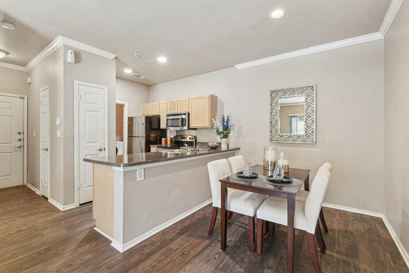 a dining room and kitchen with a table and chairs at Legends on the Green Apartments, San Antonio, TX