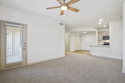 an empty living room with a ceiling fan and a kitchen at The Legends at Eagle Mountain Lake, Fort Worth, TX
