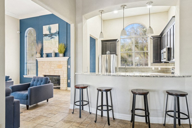 a living room with a bar and a fireplace at TalaVera Apartments, San Antonio, Texas