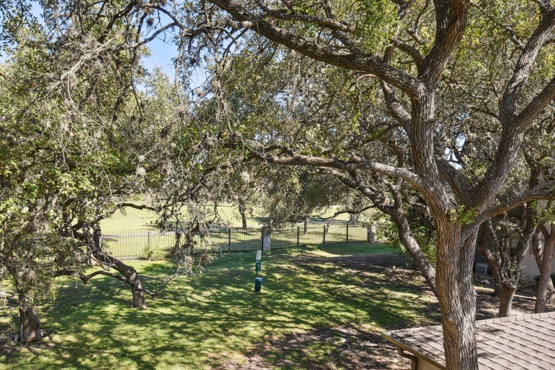 a view of a park with trees and a fence at Legends on the Green Apartments, San Antonio, TX