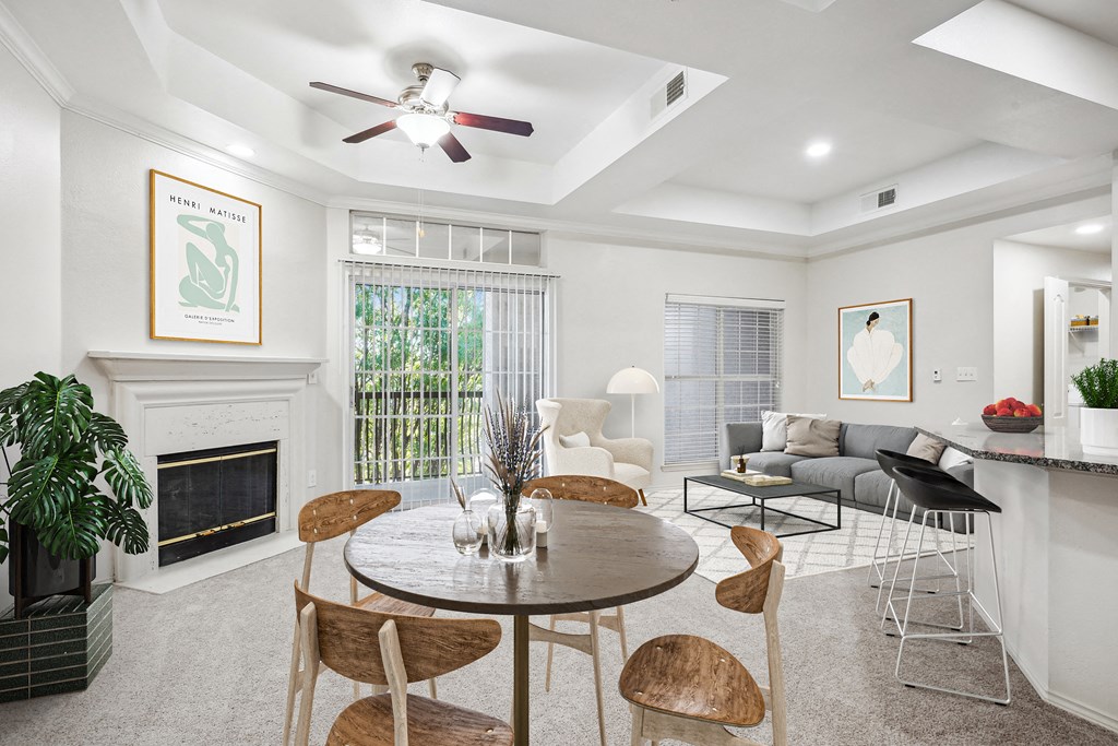 a living room with a table and chairs and a fireplace at La Ventura Apartments, Plano, 75093