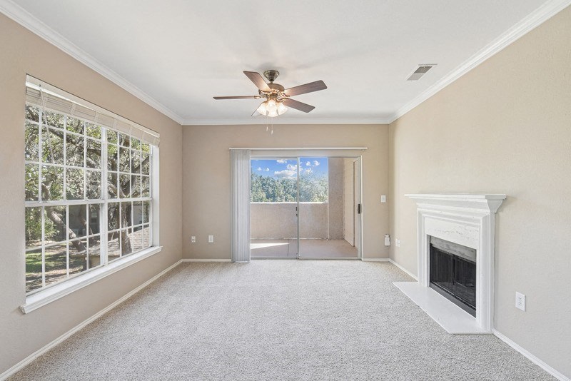 an empty living room with a fireplace and a ceiling fan at Legends on the Green Apartments, Texas, 78232