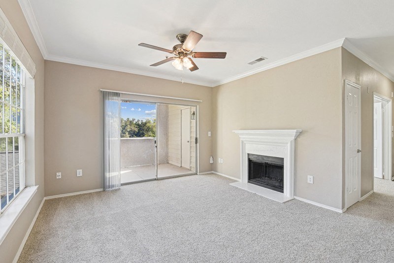 an empty living room with a fireplace and a ceiling fan at Legends on the Green Apartments, Texas, 78232
