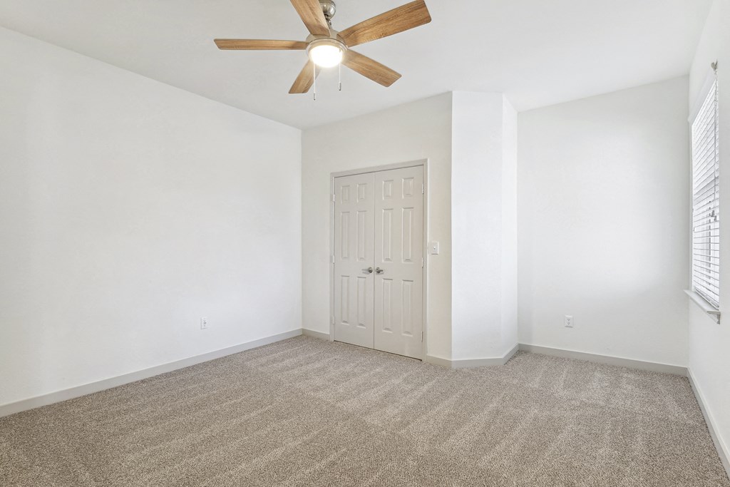 an empty living room with white walls and a ceiling fan at The Legends at Eagle Mountain Lake, Texas, 76179