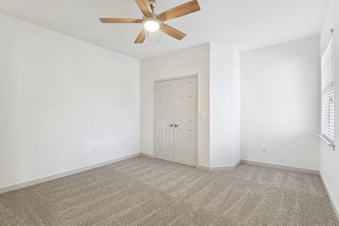an empty living room with white walls and a ceiling fan at The Legends at Eagle Mountain Lake, Texas, 76179