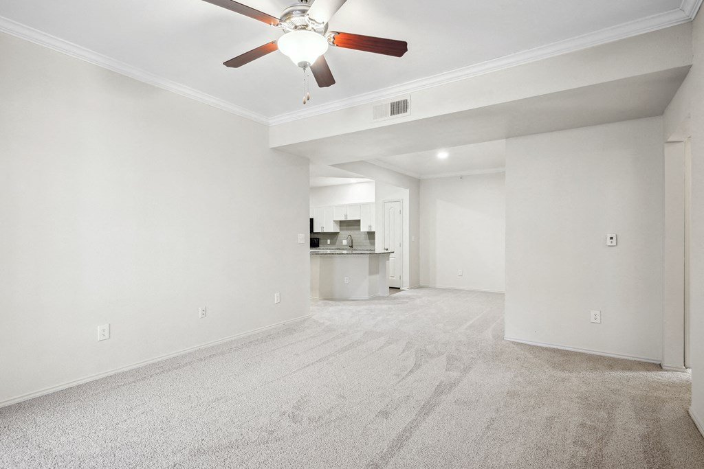 an empty living room with white walls and a ceiling fan at La Ventura Apartments, Plano, TX, 75093