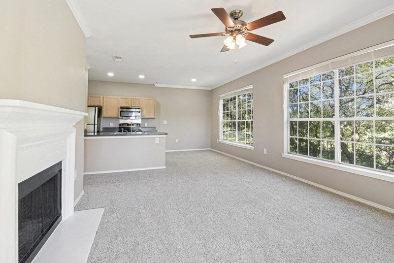 an empty living room with a fireplace and a ceiling fan at Legends on the Green Apartments, San Antonio, TX, 78232