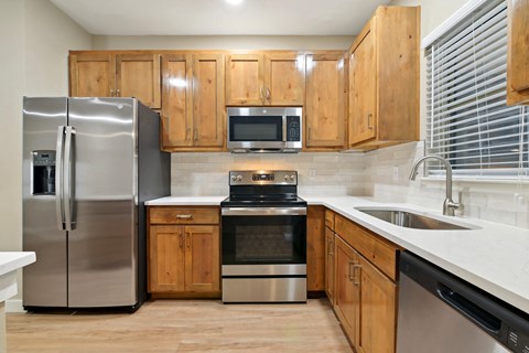 a kitchen with stainless steel appliances and wooden cabinets