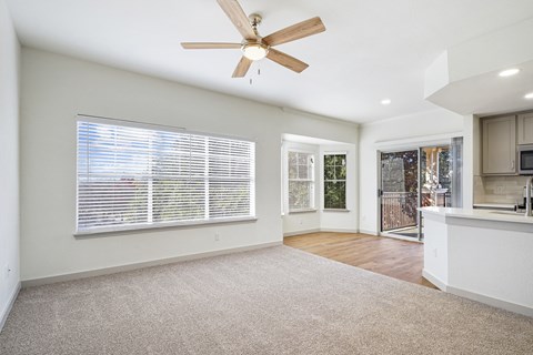 an empty living room with a ceiling fan and a kitchen at The Legends at Eagle Mountain Lake, Fort Worth, Texas