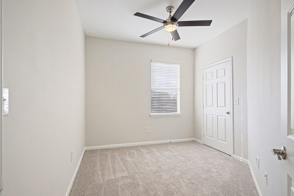 an empty room with a ceiling fan and a white door at The Legends at Eagle Mountain Lake, Fort Worth, TX