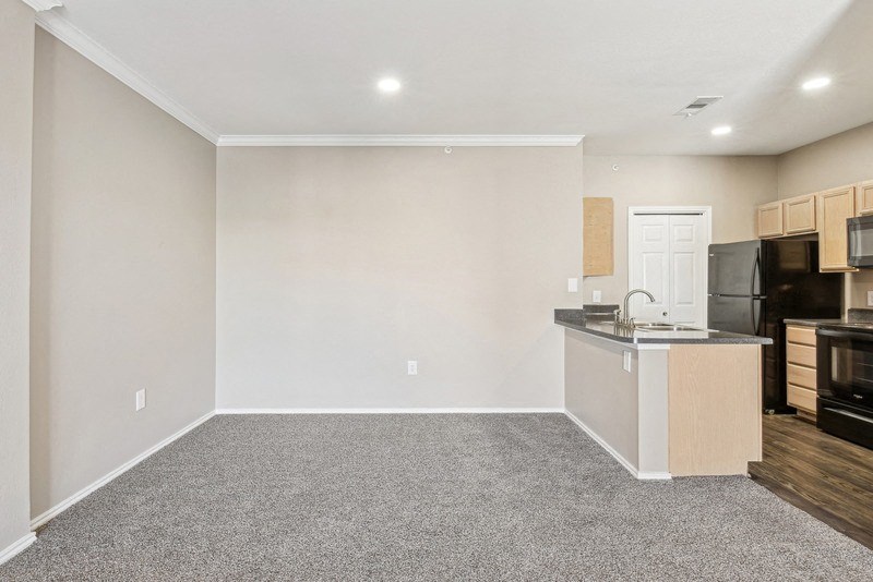 an empty room with a kitchen and a counter top in it at TalaVera Apartments, San Antonio 78232