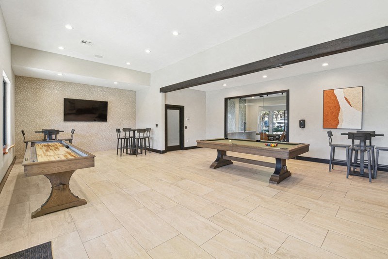 the game room with two pool tables and a television at Legends on the Green Apartments, San Antonio, Texas